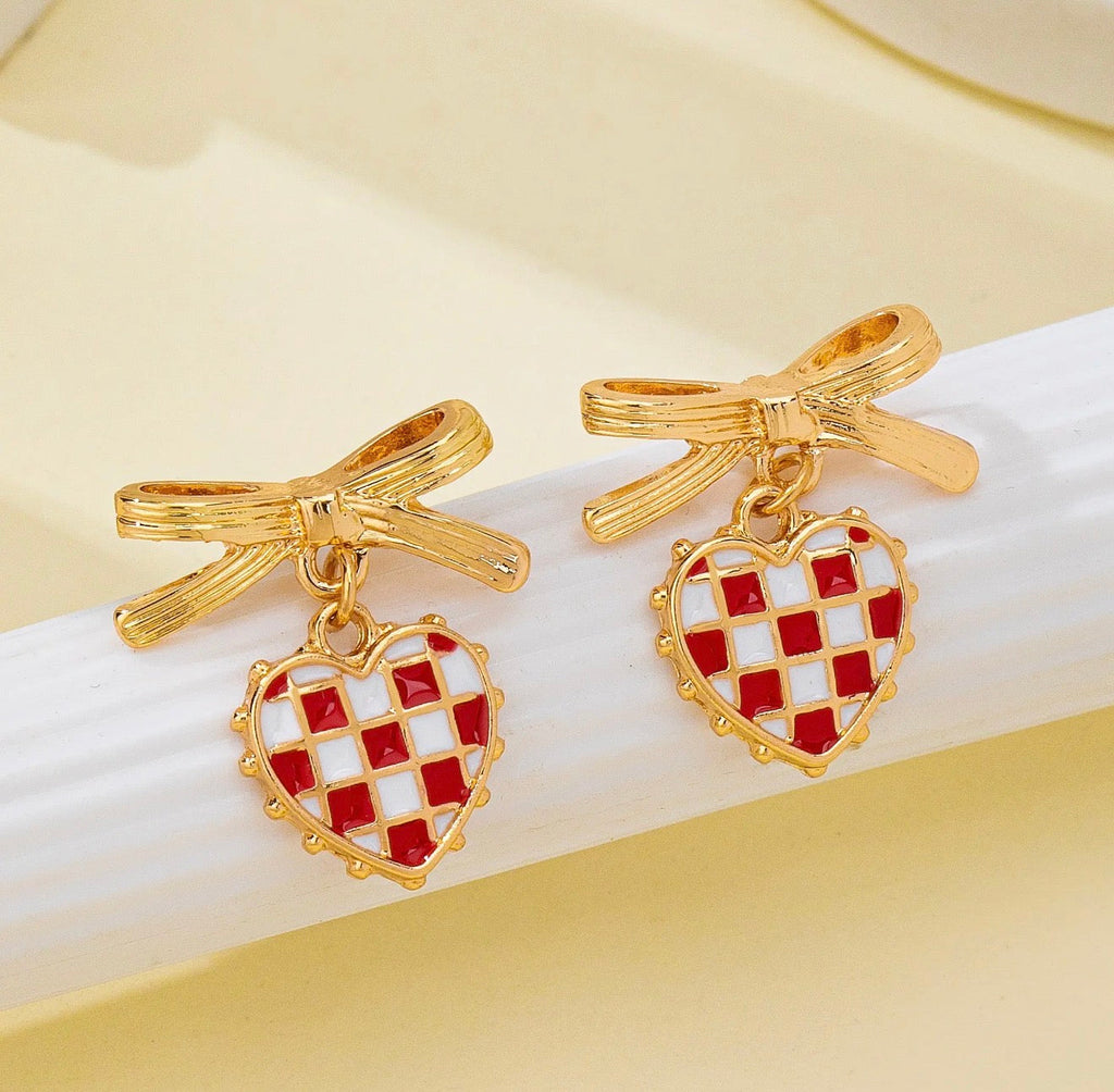 Gold bow drop earrings with red and white checkered heart charms